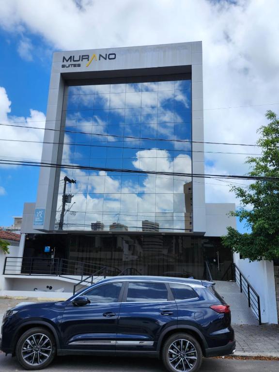 a blue suv parked in front of a building at Murano Suits Hotel in João Pessoa