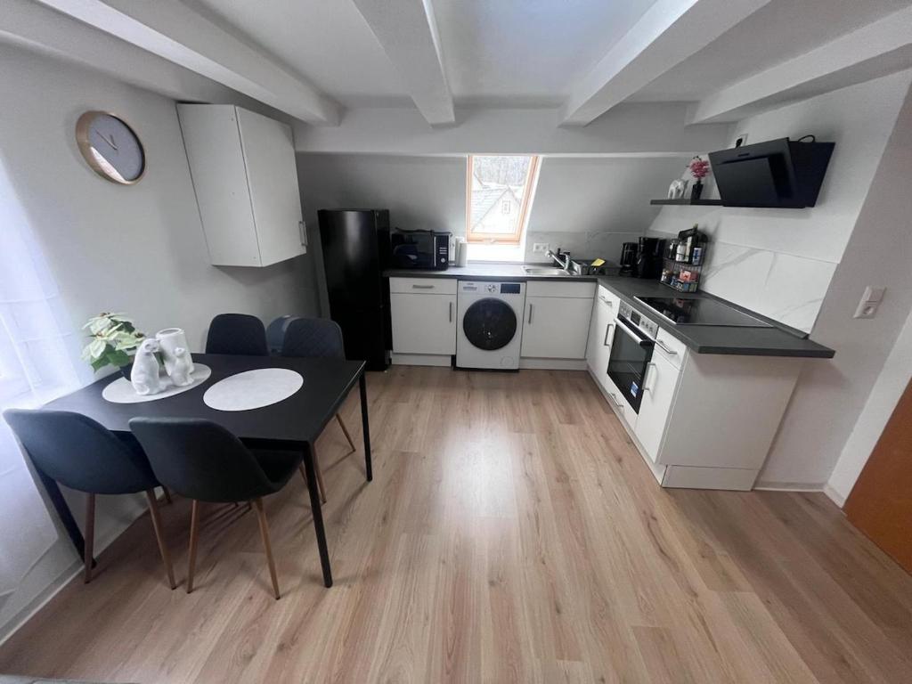 eine kleine Küche mit Tisch und ein Esszimmer in der Unterkunft Team at Home Gemütliches Dachgeschossapartment in Blaubeuren