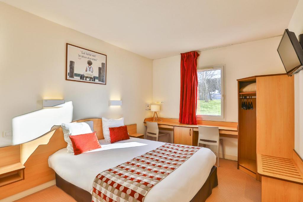 een hotelkamer met een groot bed en een bureau bij ACE Hôtel Vendée Saint Hermine in Sainte-Hermine