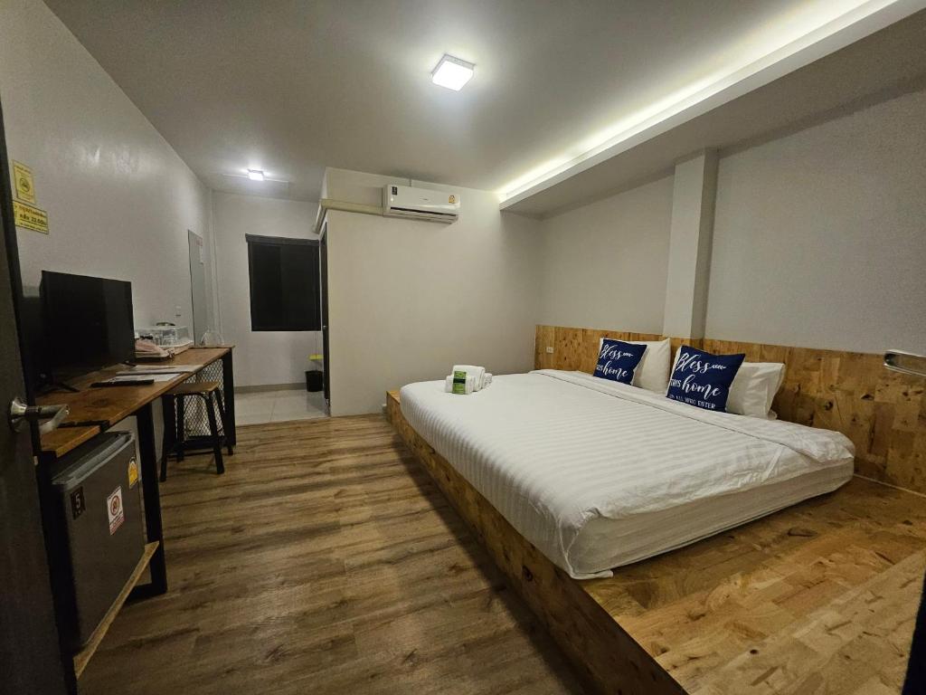 a bedroom with a bed and a desk and a television at ชวนไดอารี่ Chuan Diary in Ban Nong Bua