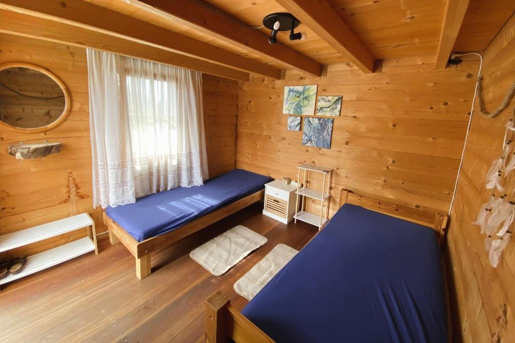 a room with two beds in a log cabin at Blockhütte am Flugplatz mit Pool in Kühndorf