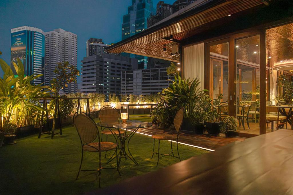 eine Terrasse mit Stühlen und einem Tisch mit Blick auf die Stadt in der Unterkunft Metro Pratunam Boutique Hotel in Pratunam