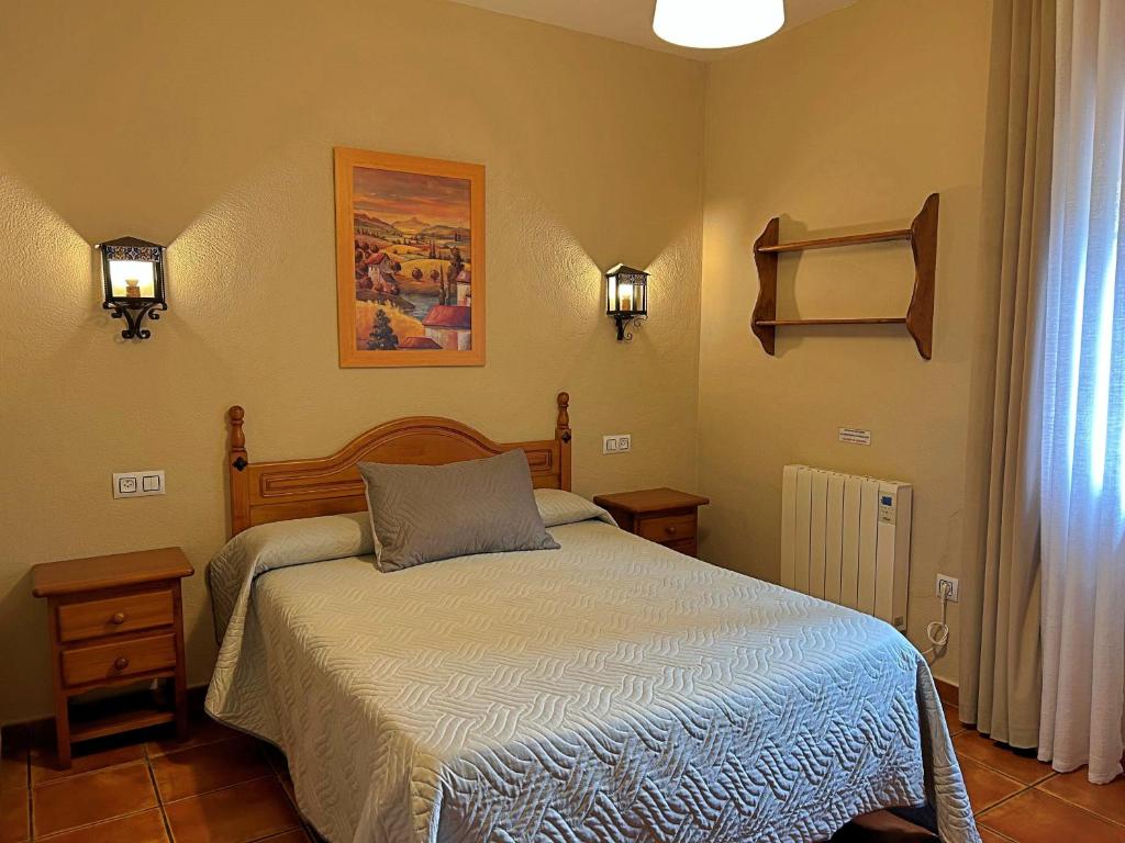 ein Schlafzimmer mit einem Bett und zwei Lampen an der Wand in der Unterkunft Casa Laguna del Maiz cazorla in Burunchel