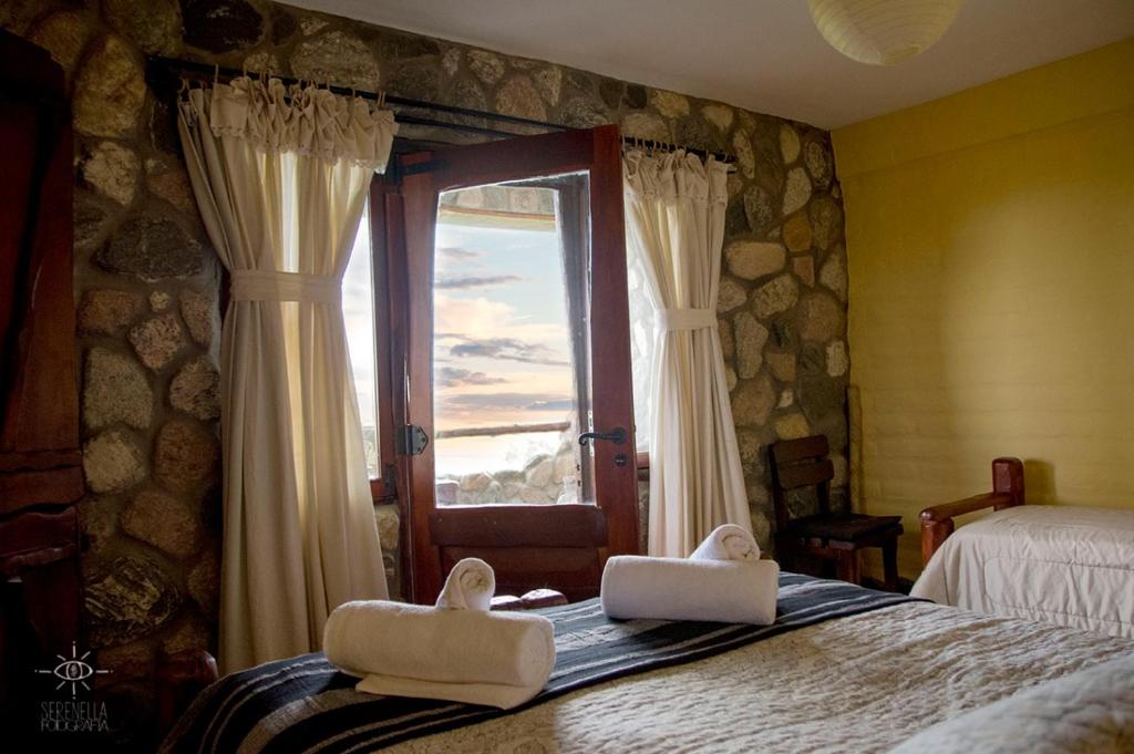 een slaapkamer met een raam en twee witte schoenen op een bed bij Hostería Vegetariana in Country Club Chumamaya