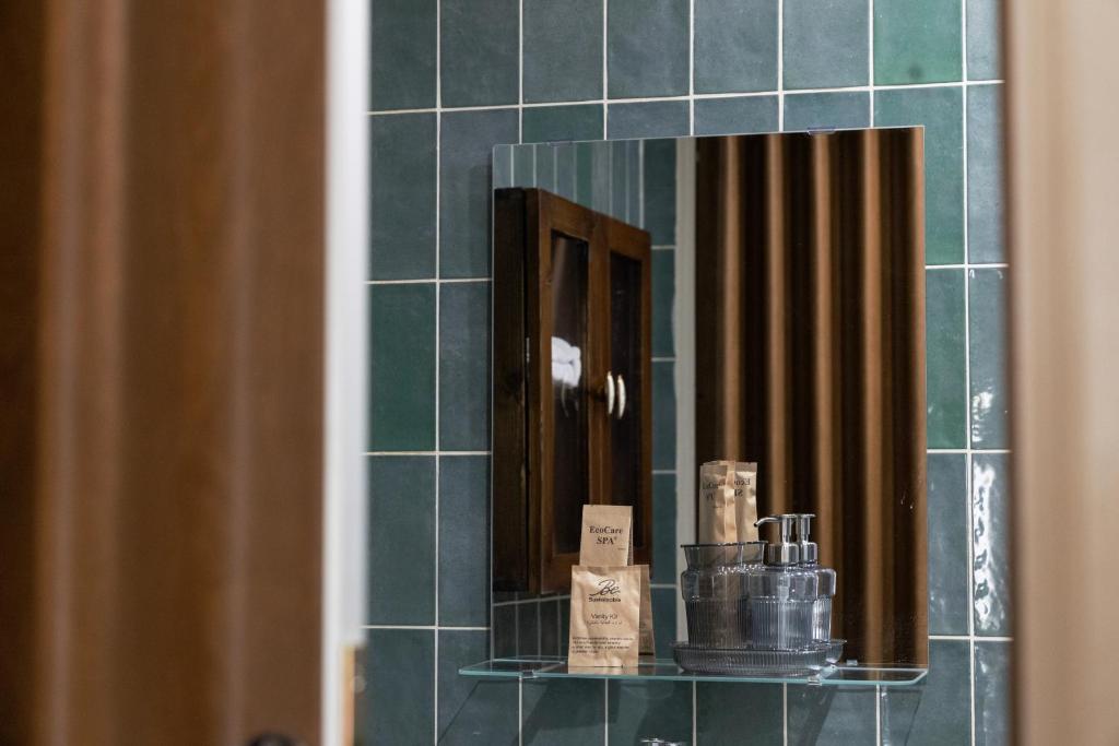 a mirror in a bathroom with green tile at بيت أبي علي in Abha
