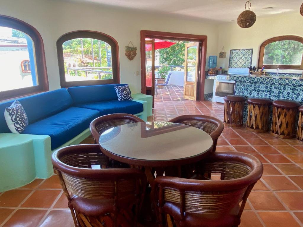 a living room with a blue couch and a table and chairs at Estrella - Casa MoJo's airy 2BR, kitchen, pool in Sayulita