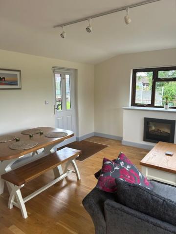 a living room with a table and a couch at Private modern guest house in Yetminster