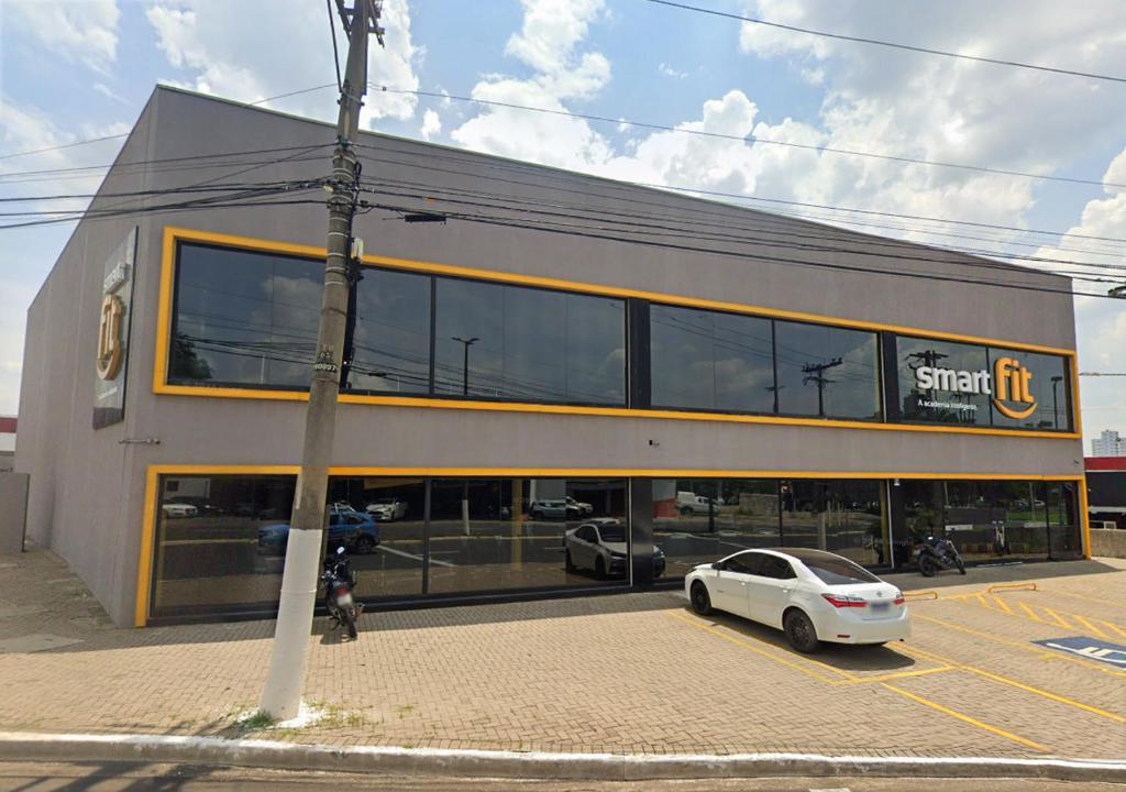 a car parked in a parking lot in front of a store at Flat Apartamento Av Esmeralda em Marília in Marília