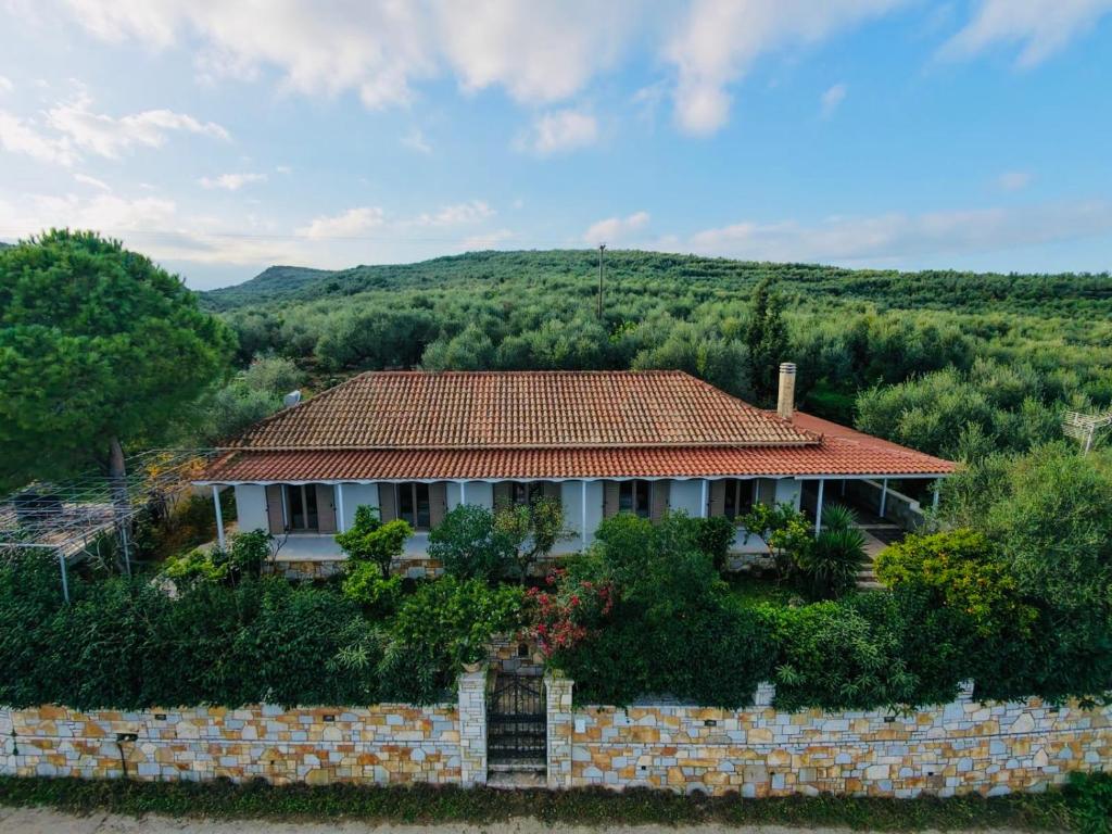 a house with a brick wall in front of a hill at Steno Villa Amoudi in Amoudi