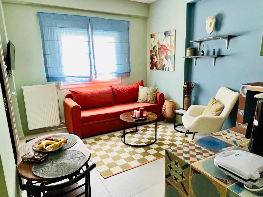 een woonkamer met een rode bank en stoelen bij Casa dell'Arte in Volos