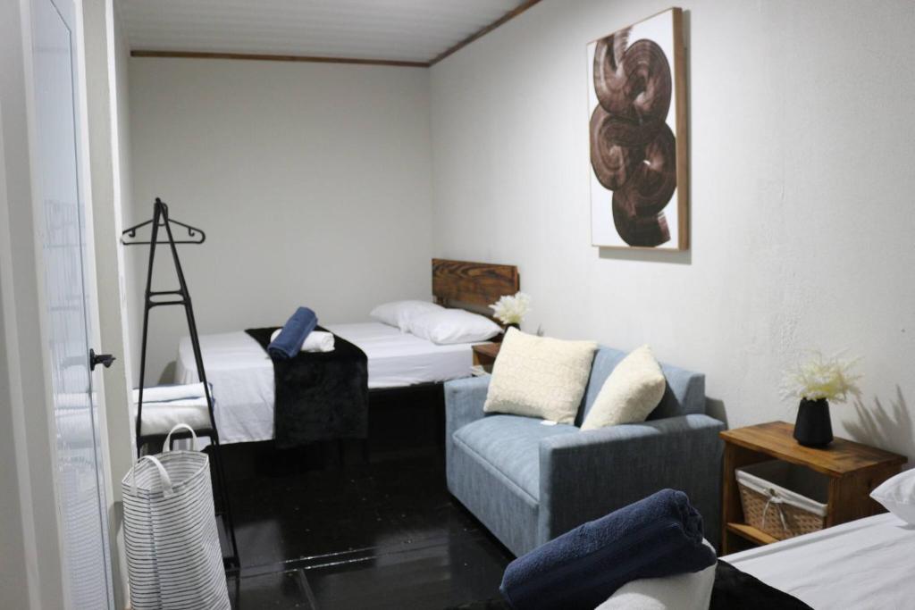 un salon avec deux lits et un canapé dans l'établissement Cozy 1BR Beachside Apartment Entre Olas, à Vega Baja