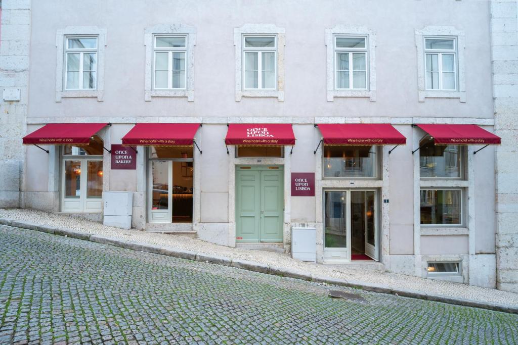 een gevel van een gebouw met rode luifels bij Once Upon Lisboa in Lissabon