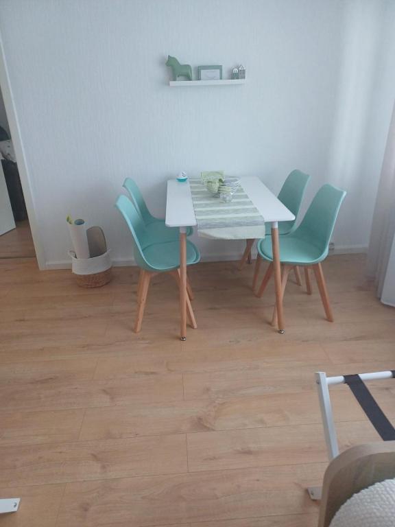 a dining room table with four chairs and a white table at Gästewohnung Illa in Meerbusch