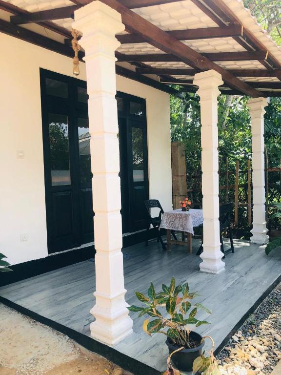 a house with a wooden porch with a wooden deck at Nimal's villa in Midigama East