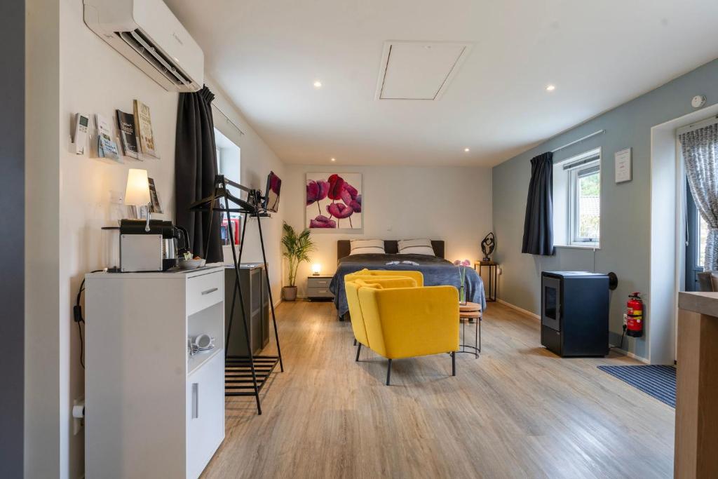 a bedroom with a bed and a yellow chair at Bed and breakfast Stiens in Stiens