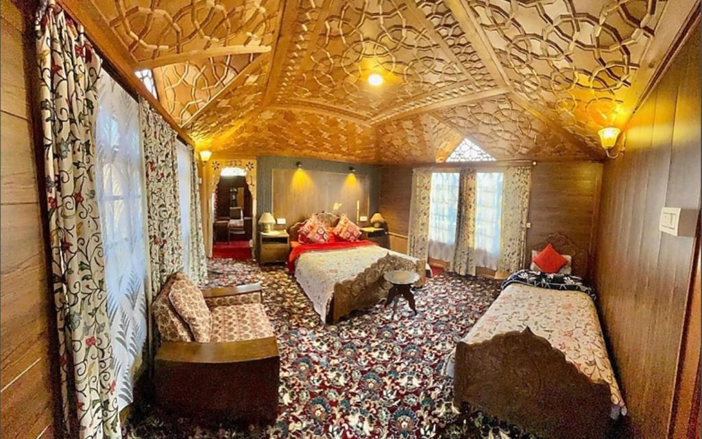 a bedroom with two beds and a coffered ceiling at Vanda Heritage Houseboats in Srinagar