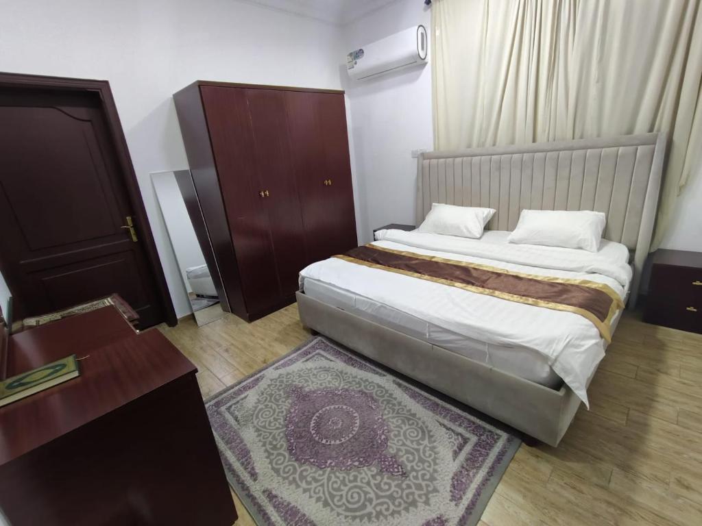 a bedroom with a large bed and a wooden floor at العروسة للشقق المخدومة in Tabuk