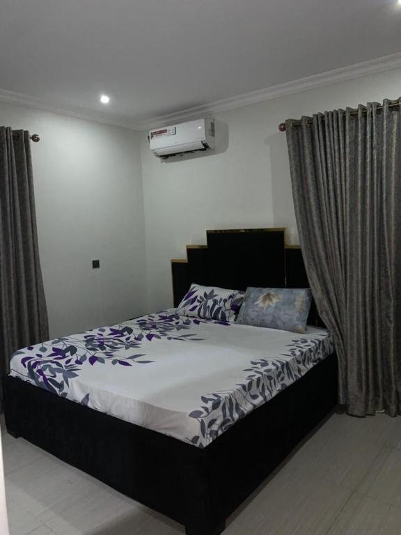 a bedroom with a large bed with purple sheets at Gracepointapartments in Lekki