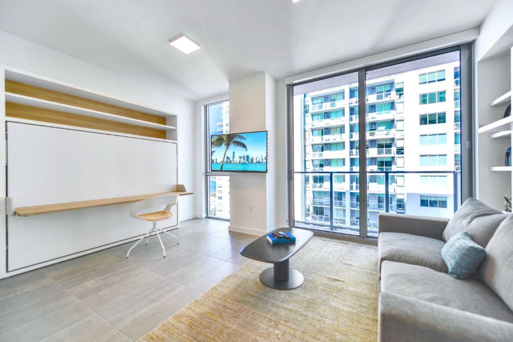 a living room with a couch and a large window at Stylish Studio in Brickell Core in Miami