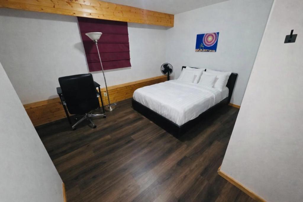 a bedroom with a bed and a desk and a chair at Bujaks in Inuvik