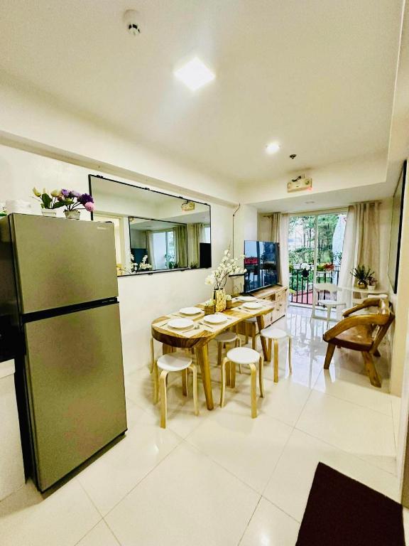 a kitchen and dining room with a table and a refrigerator at 2BR Burnham Hill Condominium in Baguio