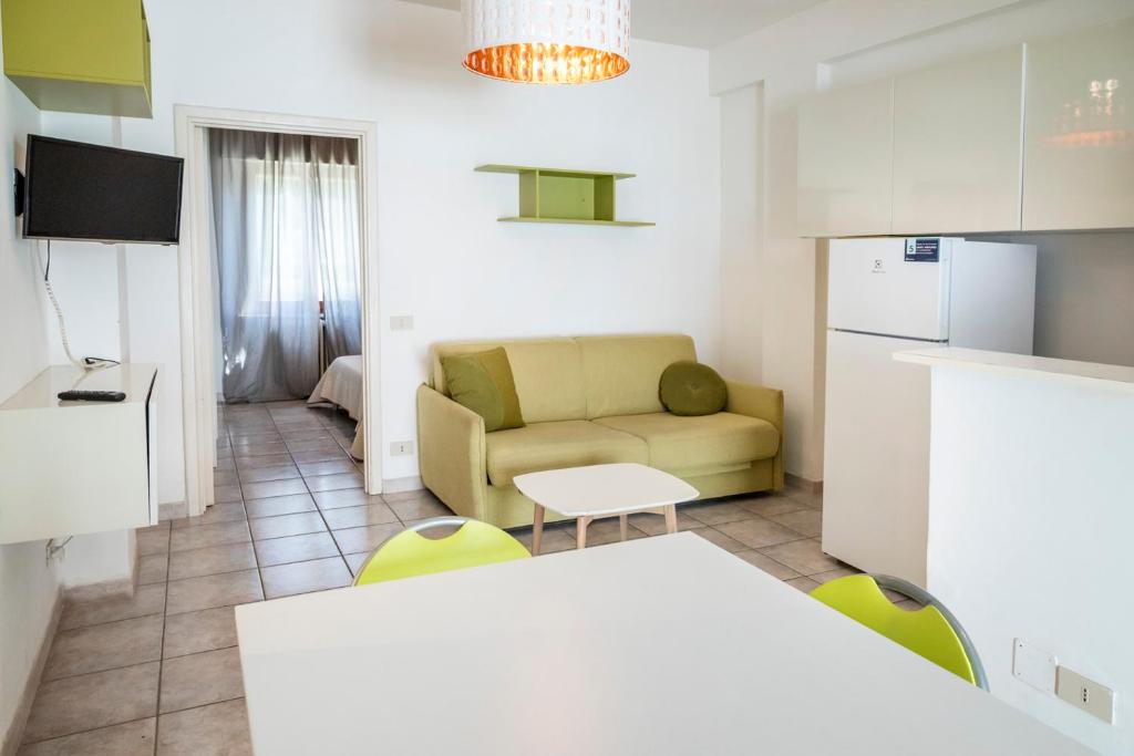 a kitchen and a living room with a couch and a table at M377 - Marcelli, bilocale con corte esterna e posto auto in Marcelli