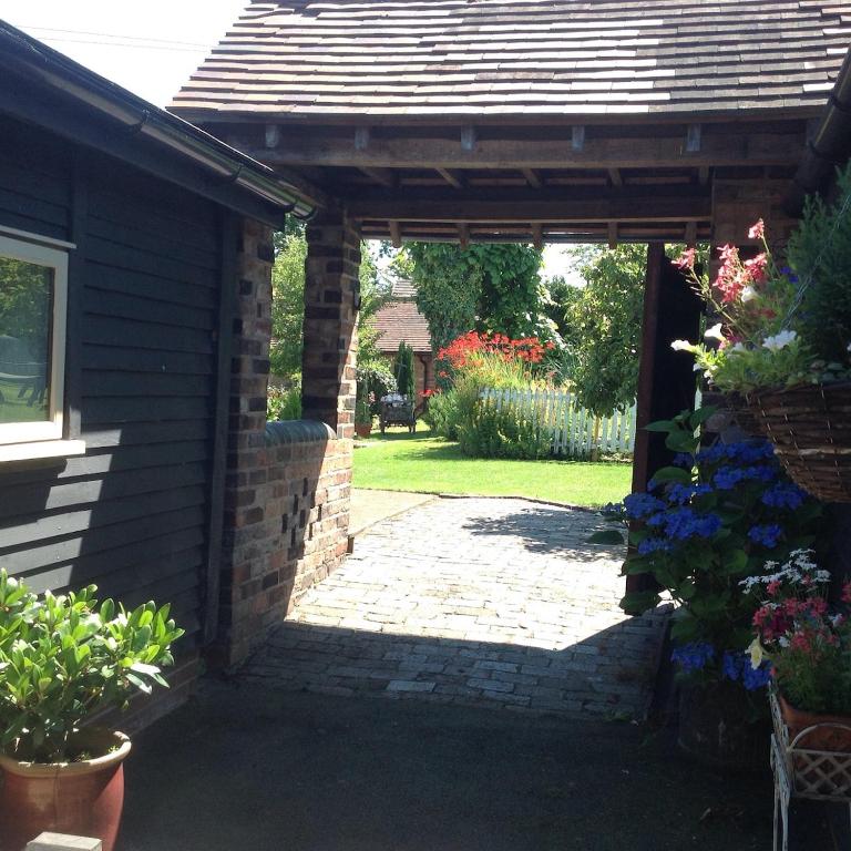 an entrance to a garden with a wooden pergola at The Stable in Stourton in Stourbridge