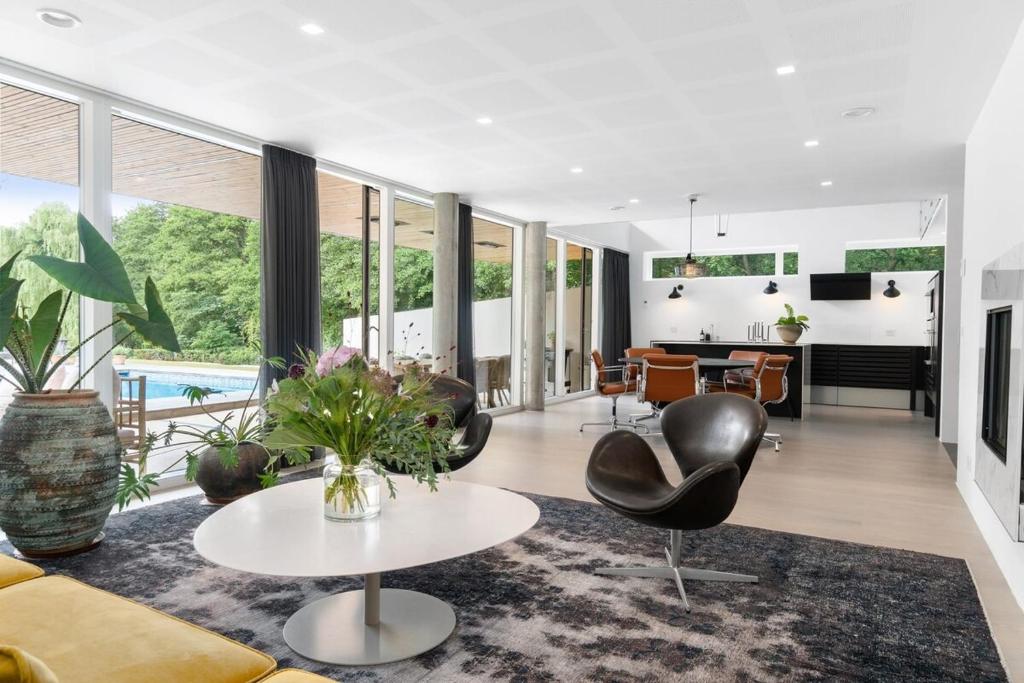un soggiorno con un divano, sedie e un tavolo di Exclusive Duplex Mansion with Jacuzzi & Pool a Charlottenlund