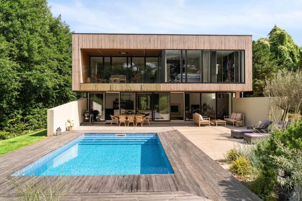 a house with a swimming pool in front of it at Exclusive Duplex Mansion with Sauna & Pool in Charlottenlund