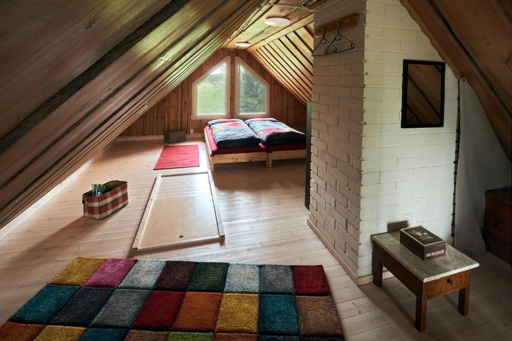 een zolderkamer met een bed en een tapijt bij Capture Nordic Wilderness Camp in Ilomantsi