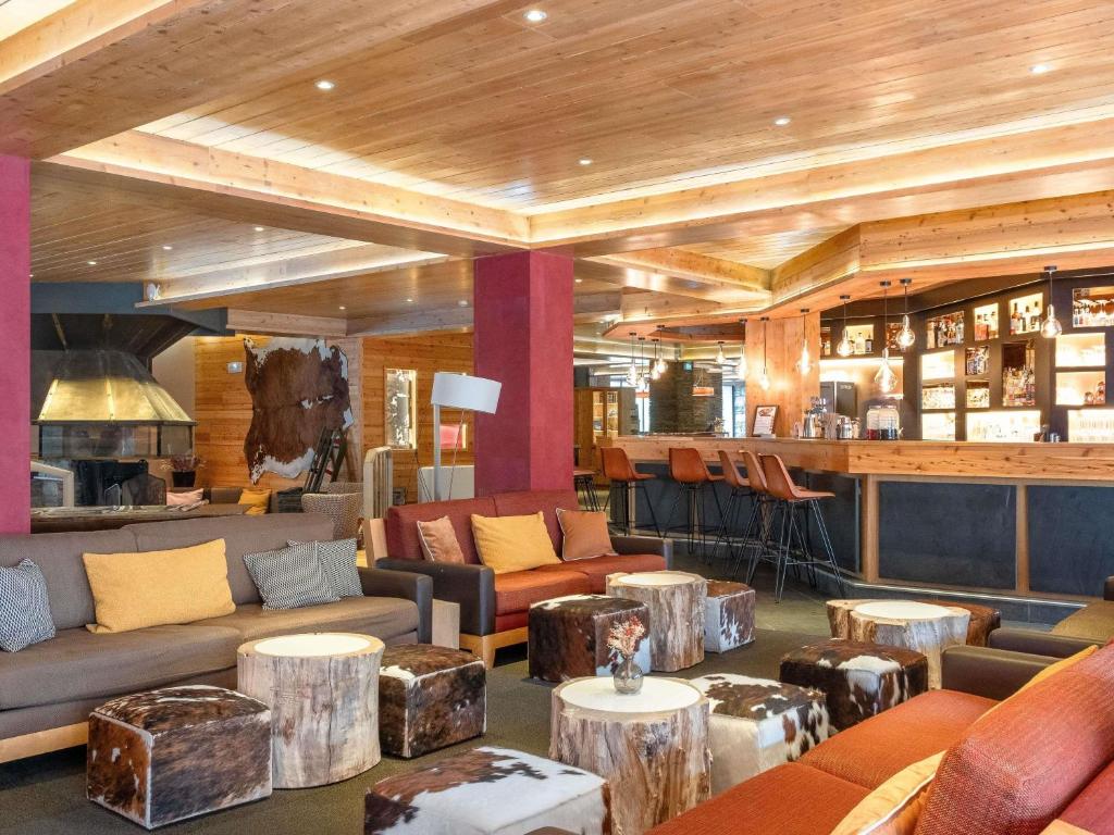 een lobby met banken en tafels en een bar bij Mercure Saint-Lary in Saint-Lary-Soulan