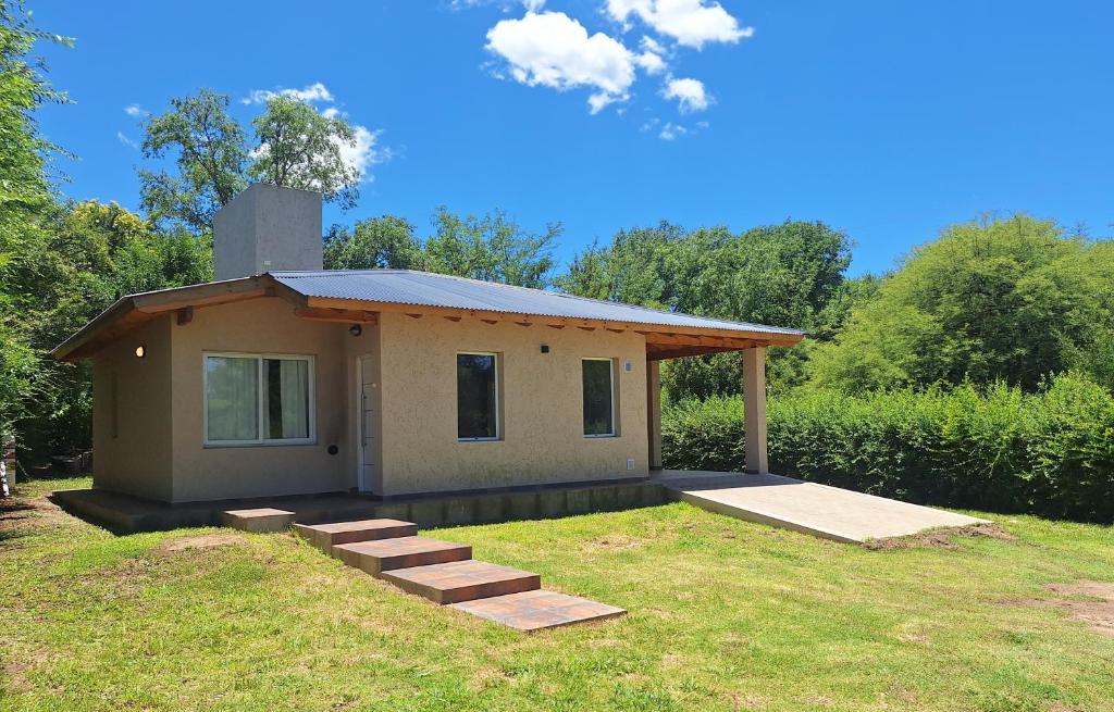 a small house with a porch and some grass at Casa Rincon in Villa General Belgrano