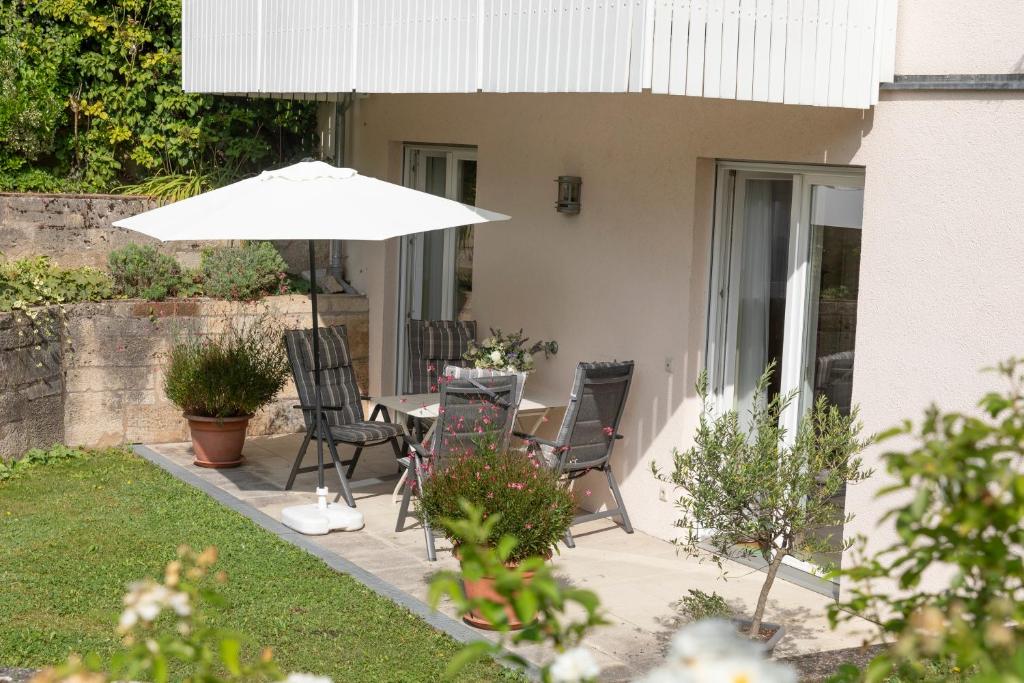 un patio con un tavolo e un ombrellone di Gästehaus Pfeiffer a Bad Mergentheim