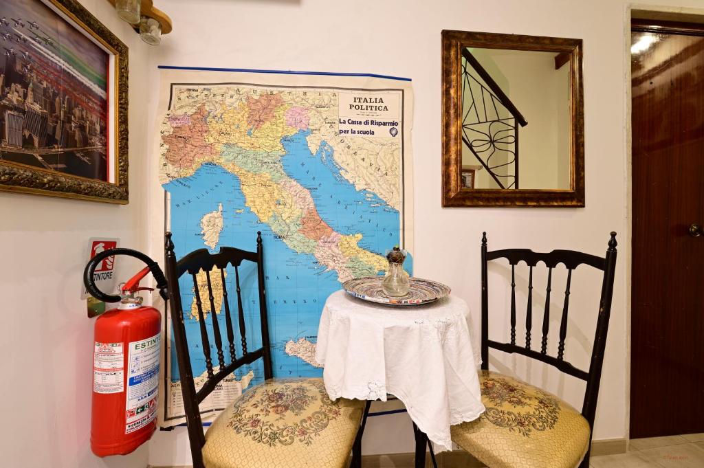 a table and two chairs with a map on the wall at Il Cavalliere Bed & breakfast in Barletta