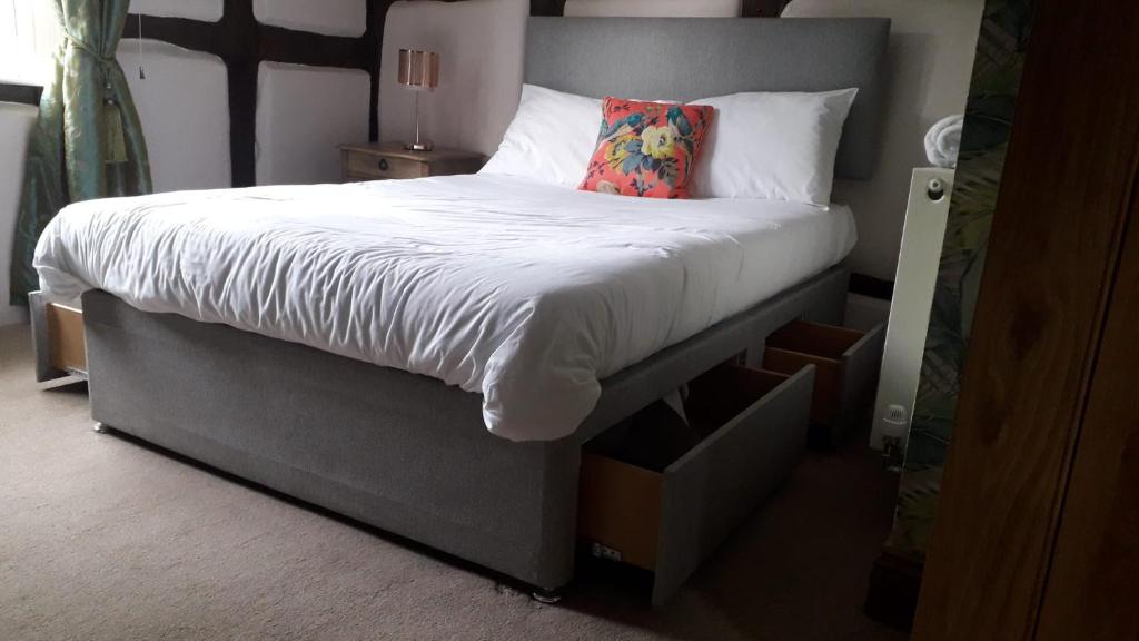 un letto con piumone bianco e cuscino sopra di Silvermead stables a Plymouth