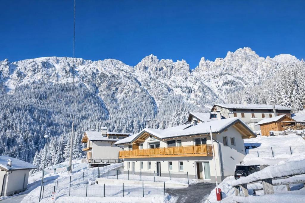 a ski resort with snow covered mountains in the background at Miravalli Home in Gosaldo