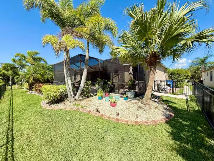een tuin met palmbomen en een huis bij Loft à louer in Apollo Beach