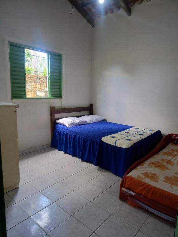 una camera da letto con due letti e una finestra di Casa temporada Cavalcante Goiás a Cavalcante