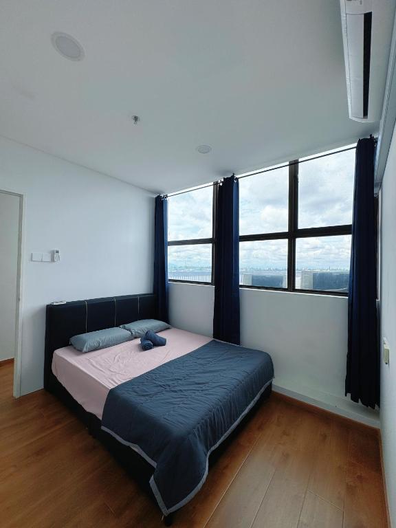 a bedroom with a bed in a room with windows at Make Memories Residence 2BR Summer Mall Kota Samarahan in Kota Samarahan