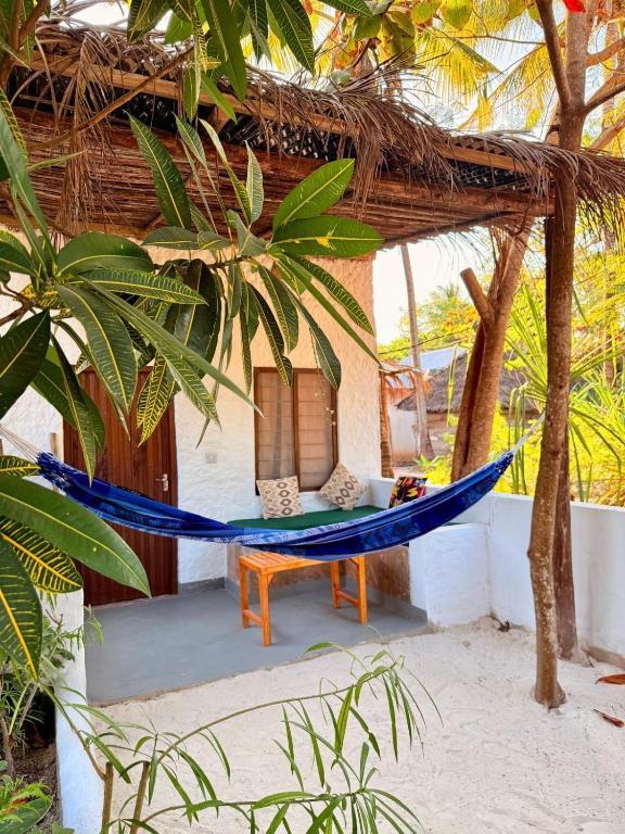a hammock in front of a house on the beach at Karanga Bungalows in Michamvi