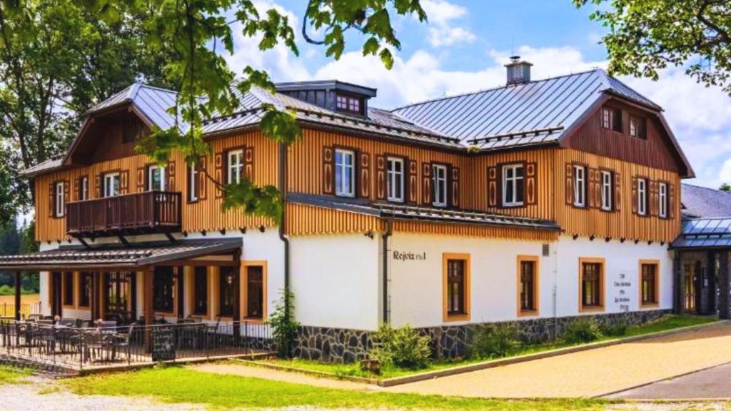 een groot oranje en wit gebouw met veel ramen bij REJVÍZ 1 Hotel & Spa in Rejvíz