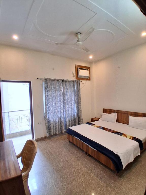 a bedroom with a bed and a table and a window at WoodsPicker in Rishīkesh