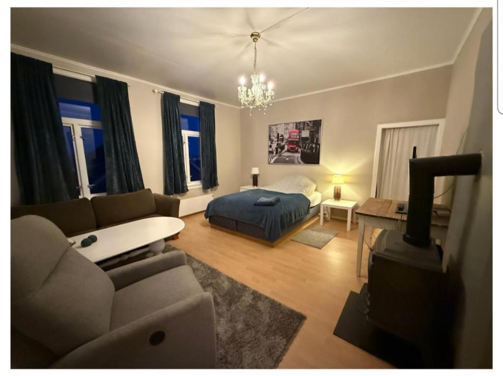 ein Wohnzimmer mit Sofa und Bett in der Unterkunft Vårsol Overnatting i Vardø centrum in Vardø