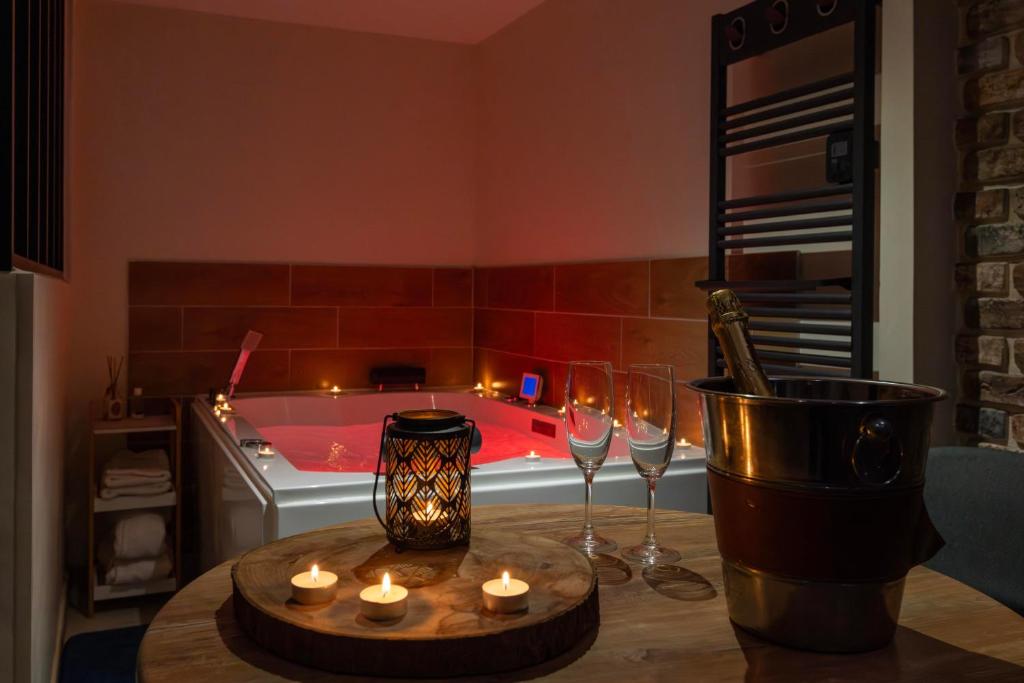 a bath tub with a table with candles and wine glasses at Au Spa de LLEA in Avignon