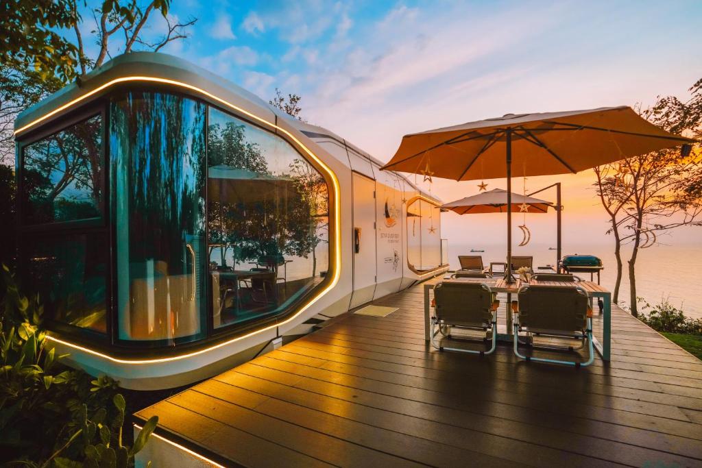 ein Zug mit Tisch und Stühlen auf einem Deck in der Unterkunft STAR OVER SEA By Deep night in Ban Samae San