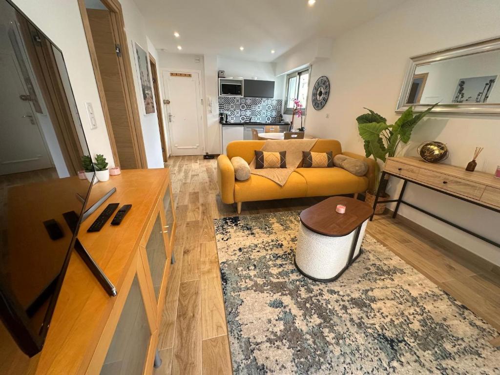 un soggiorno con un divano e un tavolo di Appartement Cosy a Cannes
