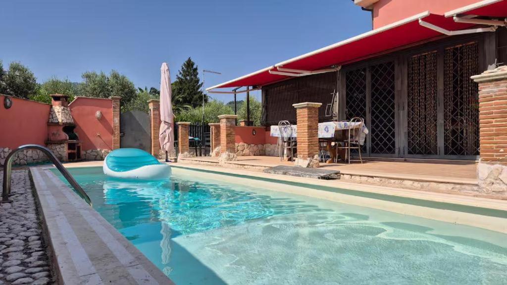 een zwembad met een boot in het water bij Cristian Case Vacanza in Colonna