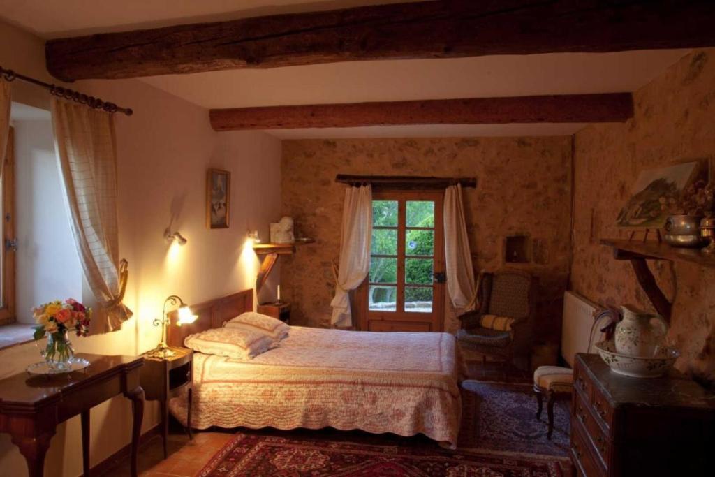 een slaapkamer met een bed en een raam bij La genivriere in Bugarach