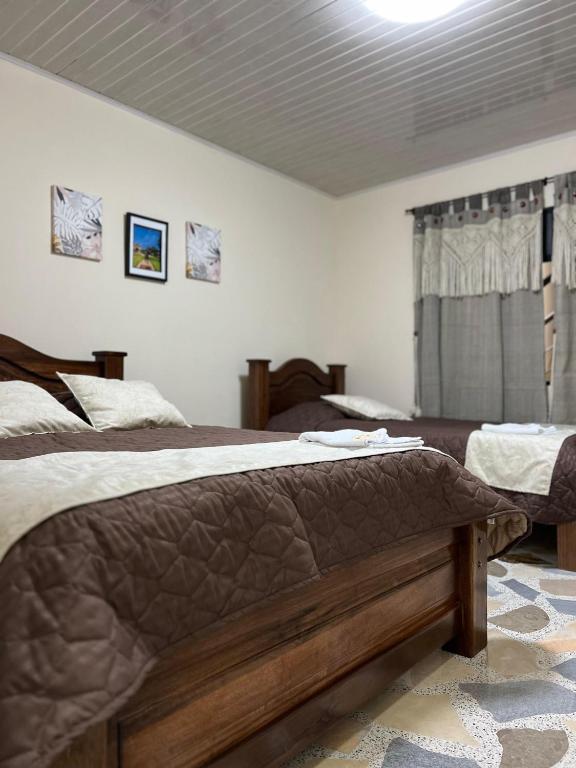 a bedroom with two beds and a window at Hotel Villalva, Cucunuba Cundinamarca in Cucunubá