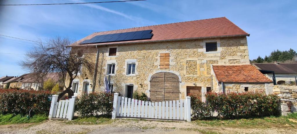 a house with solar panels on it with a white fence at Gite Le Tamaris in Mantry